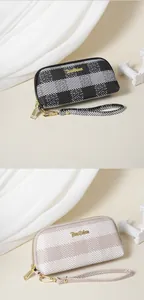 Dettaglio di due pochette a righe in nero/bianco e beige/bianco da donna