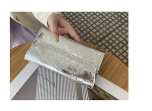 Vista detallada de una cartera larga moderna en plata metalizada con textura agrietada