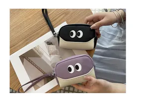 Dettaglio macro di due portamonete in pelle con occhi di cartone animato, nero e viola