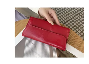 Vista detallada de la cartera larga de cuero rojo con textura agrietada y cierre imán
