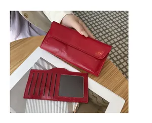 Cartera larga de cuero rojo con textura agrietada y tarjetero a juego incluido