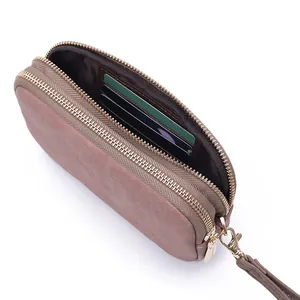 Detailed view showing the internal card slots and zippers of a dusty rose suede clutch bag