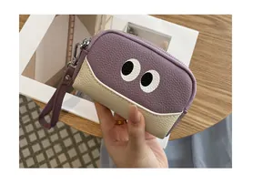 Vista dettagliata di un portamonete in pelle viola con design a occhi di cartone.