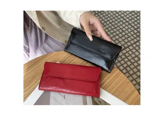Primer plano de carteras largas ultrafinas de cuero agrietado en color rojo y negro