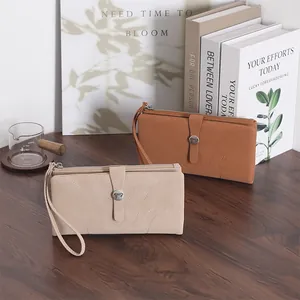 Detail der langen minimalistischen Geldbörsen in Hellbraun und Beige mit Schleife und Schlaufe.