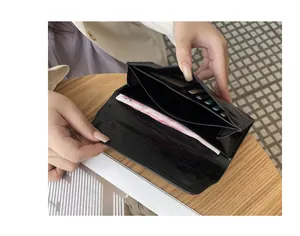 Detalle de cartera larga de cuero negro agrietado con ranuras para tarjetas