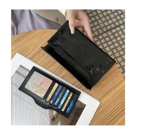 Primer plano de cartera de cuero negro con patrón agrietado, ranuras para tarjetas y cierre magnético