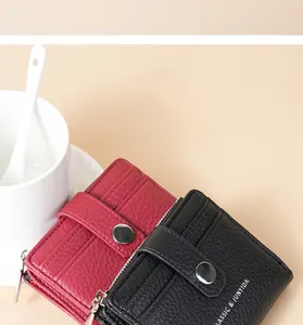 Detail shot of red and black litchi pattern PU wallets with snap button and zipper.