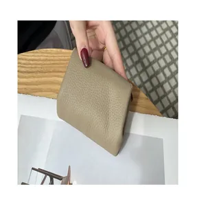 Detailed view of a minimalist khaki genuine leather coin purse with natural pebbled texture.