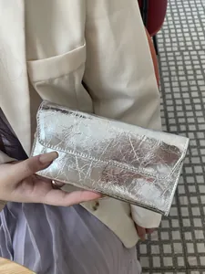 Elegante cartera larga de cuero plateado con textura agrietada, diseño delgado