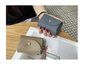 Close-up of compact pebble grain leather coin purses with metallic snap button closure