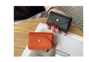 Close-up of black and orange leather coin purses with pebbled texture