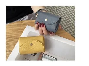 Macro detail of genuine leather mini coin purses with pebbled texture and button closure