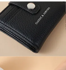 Macro detail of black lychee grain PU leather wallet with CLASSIC & JUNYIDA logo