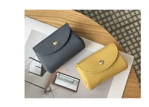 Detail view of mini genuine leather coin purses in grey and yellow with snap closure