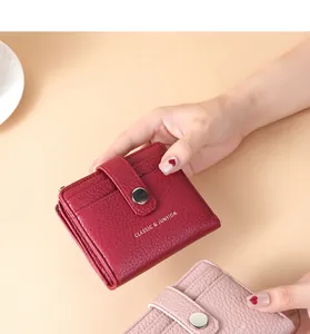 Close-up detail of stylish lychee pattern PU leather wallets in burgundy and pink colors