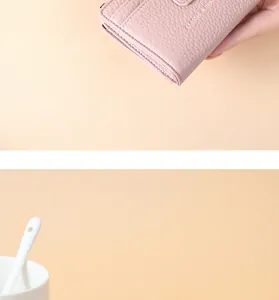 Close-up detail of pink lychee grain PU leather wallet showing textured finish and brand logo.