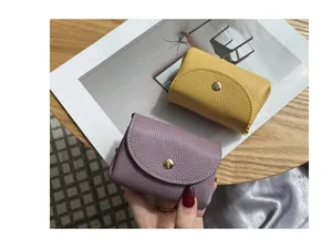Close-up showing the rich pebble grain leather texture and metallic snap button of this mini coin bag