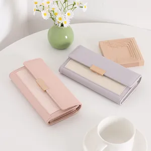Close-up of vintage women's long wallets with woven texture panels and gold buckles on a desk
