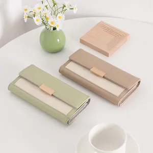 Detail view of vintage textured long wallets in light green and khaki beige colors.