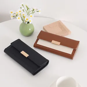 Retro long wallets in black and brown with elegant gold clasp on a white table.