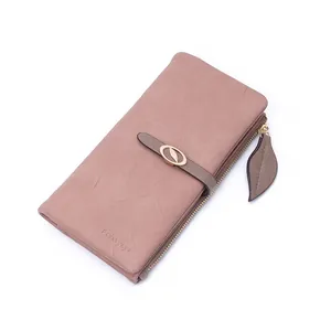 Dettaglio di un elegante portafoglio lungo rosa da donna con fibbia a foglia e cerniera