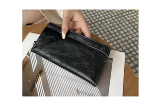 Gedetailleerde weergave van een slanke zwarte damesportemonnee van gestructureerd leer vintage