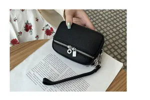 Detailed view of black lychee pattern coin purse with double silver zippers and wrist strap