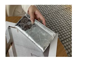 Detailopname van een slanke metallic zilveren damesportemonnee met elegant kreukeltextuurontwerp