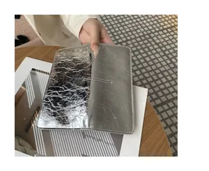 Detailopname van slanke zilveren metallic leren portemonnee met zachte textuur