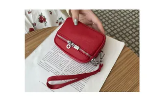 Detail of mini red leather coin purse featuring double zippers and functional wristlet