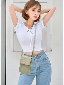 Elegante bolso bandolera verde salvia para móvil con textura arrugada en una modelo