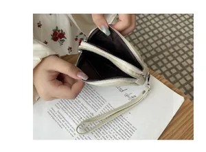 Detailed view of the double zipper interior of a cream mini coin pouch