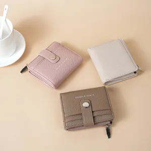 Fashionable lychee pattern PU leather short wallets in pink, beige, and taupe colors.