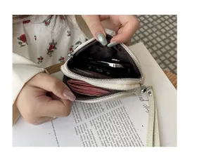 Close-up of the mini double zipper coin purse showing internal storage for cash and keys