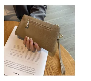 Detail view of the pebbled leather wristlet with secure gold-tone metal zipper and strap