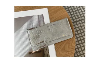 Detailopname van een zilveren metallic gekreukelde lederen portemonnee voor dames