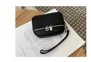 Detail of mini black lychee pattern leather coin purse with double silver zippers