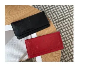 Detailopname van zwarte en rode getextureerde lederen lange portemonnees op tafel
