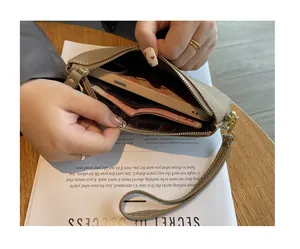 Detailed interior view of the khaki leather wristlet bag showing phone and cash storage