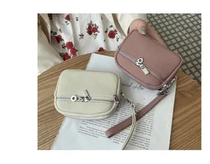 Detailed view of mini pebble leather coin purses with double zippers and wrist straps