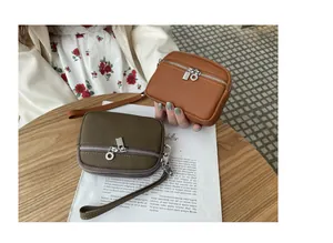 Detail view of two mini leather coin purses with double zippers on a wooden table