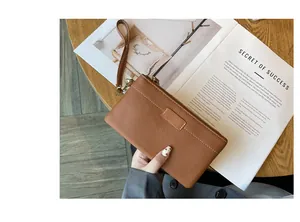 Brown pebble leather wristlet pouch with zipper closure and wrist strap
