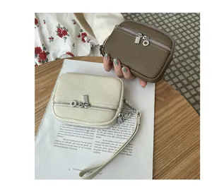 Detail of mini pebble leather coin purses with double zippers in a lifestyle setting