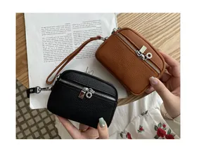 Detail shot of handheld mini double zipper coin purses in black and brown leather