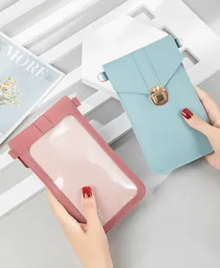 Minimalist touchscreen crossbody phone bag with gold-tone lock and clear window.