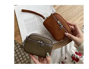 Detail view of pebbled texture and double zippers on these mini leather pouches