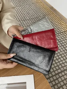 Detailweergave van de zachte lederen portemonnees voor dames in zwart, rood en zilver.