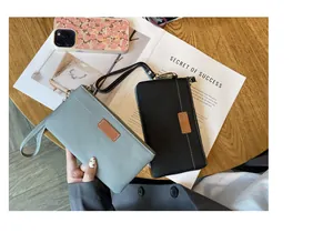 Detailed view of genuine leather wristlet pouches in light blue and black colors