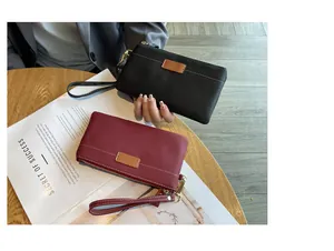 Close-up showing black and burgundy genuine leather clutch bags with wrist straps